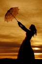 Silhouette of a woman in a dress with an umbrella blowing above Royalty Free Stock Photo