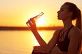 Silhouette woman drinking water from bottle after run or yoga on the beach Royalty Free Stock Photo