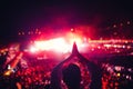 Silhouette of a woman enjoying festival lights and concert. Woman making hand gestures at concert