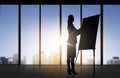 Silhouette of woman with flipboard over office