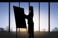 Silhouette of woman with flipboard over office