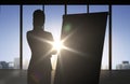 Silhouette of woman with flipboard over office