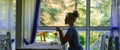 Silhouette of woman in front of window, nature background.