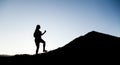 Silhouette of a woman giant strides along the mountainside as on a career ladder. Travel or business success