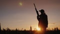 Silhouette of a woman with a gun in her hands. Hunter in the field at sunset Royalty Free Stock Photo