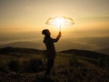 Silhouette woman hand holding umbrella on mountain at sunrise Royalty Free Stock Photo