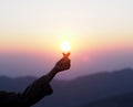 Silhouette woman hand showed mini heart finger symbol at sunrise