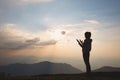 Silhouette of a woman with hands raised in the sunset concept for religion, worship, prayer and praise, Religious concepts Royalty Free Stock Photo