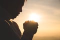 Silhouette of a woman with hands raised in the sunset concept for religion, worship, prayer and praise, Religious concepts Royalty Free Stock Photo