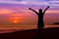 Silhouette of woman with hands up while standing on sea beach at Royalty Free Stock Photo