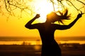 Silhouette of a woman in headphones, the girl enjoying music on the sunset