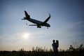 Silhouette of woman with child looking at landing commercial airplane Royalty Free Stock Photo