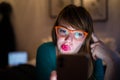 A silhouette of a woman looking at her mobile phone