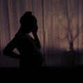 Silhouette of a woman holding her head during pregnancy. Pregnant woman in sadness at the window Royalty Free Stock Photo