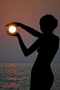 Silhouette of a woman holding the sun in her hands Royalty Free Stock Photo