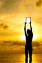 Silhouette of woman holding tablet computer at sunset Royalty Free Stock Photo