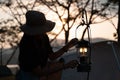 Silhouette woman igniting lantern in camping tent on campsite. adjusting light up lamp in evening. lifestyle camper Royalty Free Stock Photo