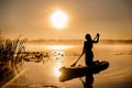 Silhouette of a woman on SUP board at dawn and the horizon with mists on the water, atmosphere of relaxation Royalty Free Stock Photo