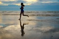 Silhouette of woman jogger running on sunset beach with reflection, fitness and sport Royalty Free Stock Photo