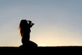 Silhouette of Woman Kneeling in Prayer and Surrender