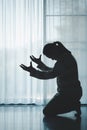 silhouette of woman kneeling and praying in modern church at sunset time. Female catholic prayer worship to God wish a better life Royalty Free Stock Photo