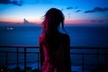 the silhouette of a woman looking out over the ocean at sunset Royalty Free Stock Photo