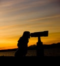 Silhouette of Woman Looking Through Telescope