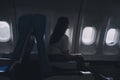 Silhouette of woman looks out the window of an flying airplane. Passenger on the plane resting beside the window Royalty Free Stock Photo