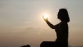 Silhouette of a woman making a wish while the sun was rising. Eucharist healing blesses the Lord, helps to repent