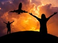 Silhouette woman and the man standing raised up arms celebrate during airplane flying in sunset Royalty Free Stock Photo