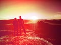 Silhouette woman and man at sunset on top mountain