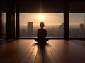 Silhouette of a woman meditating on a wooden floor.