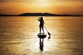 Silhouette of woman paddling at sunset on a stand up paddleboard SUP in Croatia, Adriatic Sea, near Sibenik. Tourism concept Royalty Free Stock Photo