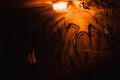 A silhouette of a woman passing in a dark red rusty tunnel with dim orange lights. Her purse is brightly lit