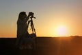 Silhouette of a woman photographer and camera on tripod Royalty Free Stock Photo