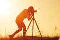 Silhouette of woman photographer shooting landscape at sunset Royalty Free Stock Photo