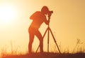 Silhouette of woman photographer shooting landscape at sunset Royalty Free Stock Photo