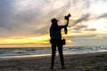 Silhouette of a woman photographer standing in the beach sunset Royalty Free Stock Photo