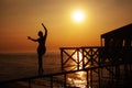 Silhouette of a woman on a pier on the seashore against the backdrop Royalty Free Stock Photo