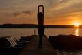 Silhouette of a woman in pier with small boats against the backdrop of the river sunset Royalty Free Stock Photo