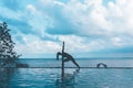 Silhouette woman practice yoga Triangle pose to meditation summer vacation on the pool above the beach Royalty Free Stock Photo