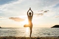 Silhouette of a woman practicing the tree yoga pose on a beach a Royalty Free Stock Photo