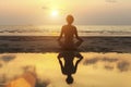 Silhouette woman practicing yoga on the beach at amazing sunset. Royalty Free Stock Photo