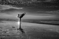 Silhouette of woman practicing yoga on the beach during a beautiful sunset. In black and white Royalty Free Stock Photo