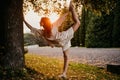 Silhouette woman practicing yoga in the forest at sunset. Meditation workout concept. Royalty Free Stock Photo