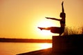 Silhouette woman practicing yoga or stretching on the beach pier at sunset or sunrise Royalty Free Stock Photo