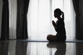 Silhouette of woman prayer position, Praying hands with faith in religion and belief in God on dark background. Power of hope or Royalty Free Stock Photo