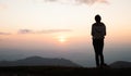 Silhouette of a woman praying outside at beautiful landscape at the top of the mountain, Copy space of man rise hand up on top of Royalty Free Stock Photo