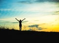 Silhouette of woman praying over beautiful sky background