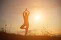 Silhouette of woman praying over beautiful sky background